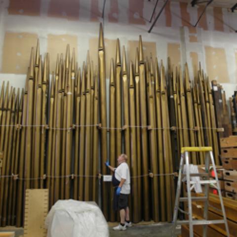 Richard Cote examines façade pipes in storage at Foley-Baker facility